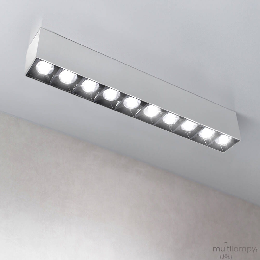 Lampa sufitowa LED w kolorze białym i czarnym, o mocy 30W i temperaturze barwowej 3000K. Prosty, prostokątny kształt z widocznymi diodami LED, zamontowana na suficie. Tło w jasnym odcieniu, co podkreśla nowoczesny design.