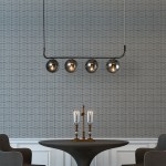 Lampa wisząca Alisa w kolorze grafitowym z czterema dymionymi kloszami w kształcie kul. Ujęcie z góry, zawieszona nad okrągłym stołem, na tle strukturalnej ściany. W widoku także stylowe świeczniki z przezroczystymi lampionami.