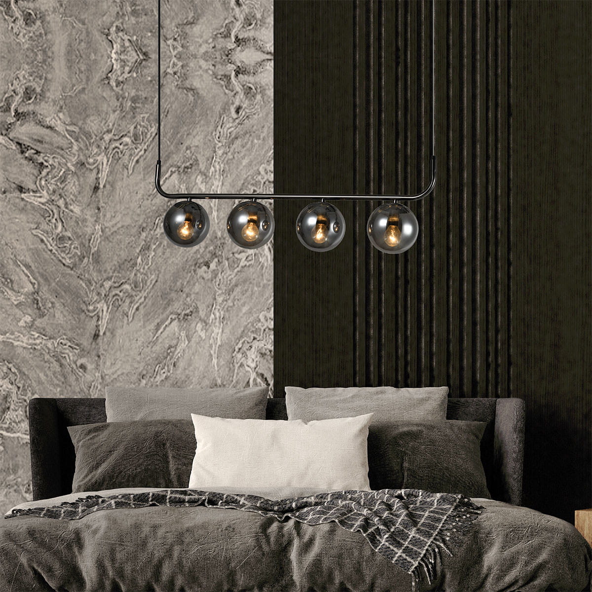 Grafitowa lampa wisząca Alisa z czterema dymionymi kloszami E14. Zawieszona nad łóżkiem w sypialni, na tle ciemnej, teksturowanej ściany i marmurowej powierzchni. Elegancki design z minimalistycznym kształtem.