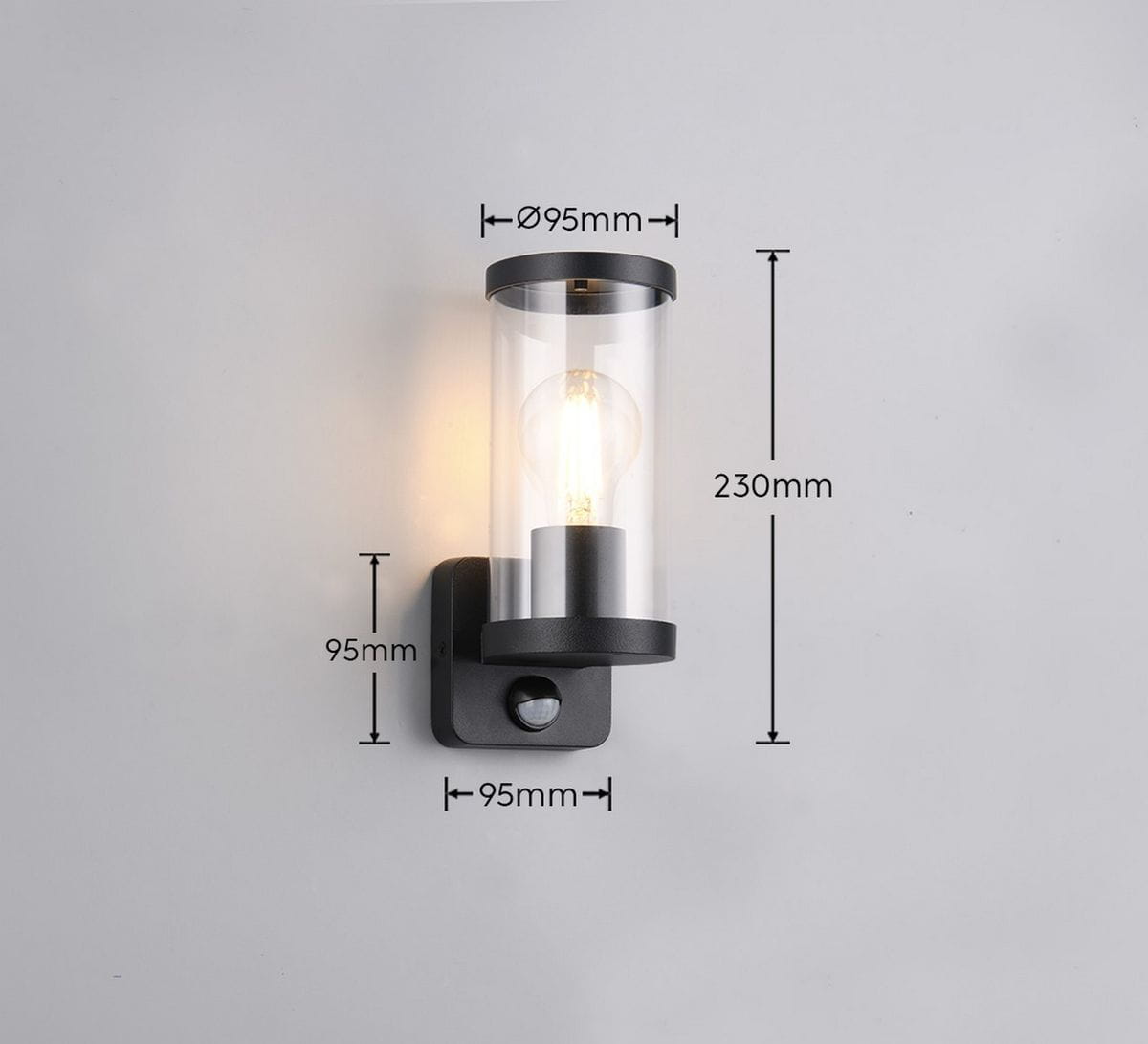 Kinkiet zewnętrzny Bonito w kolorze czarnym z czujnikiem ruchu. Średnica 95 mm, wysokość 230 mm, wykonany z metalu i szkła. Okrągła oprawka E27 z widoczną żarówką. Montowany na ścianie, z prostym tłem.
