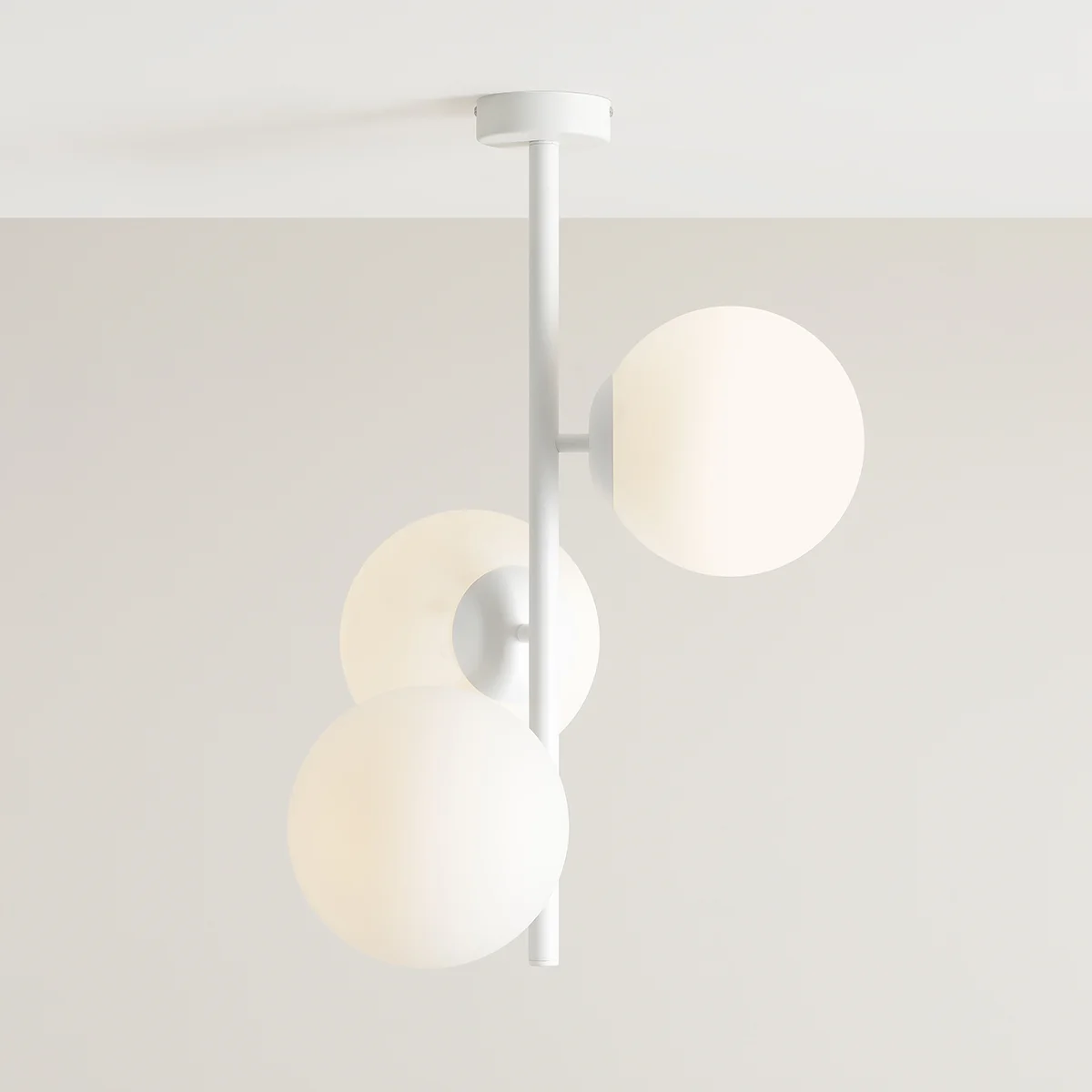 Lampa sufitowa 3-punktowa Fin M w kolorze białym, z trzema okrągłymi kloszami z matowego szkła, zamontowana na prostej metalowej konstrukcji. Ujęcie z góry, podkreślające minimalistyczny design.