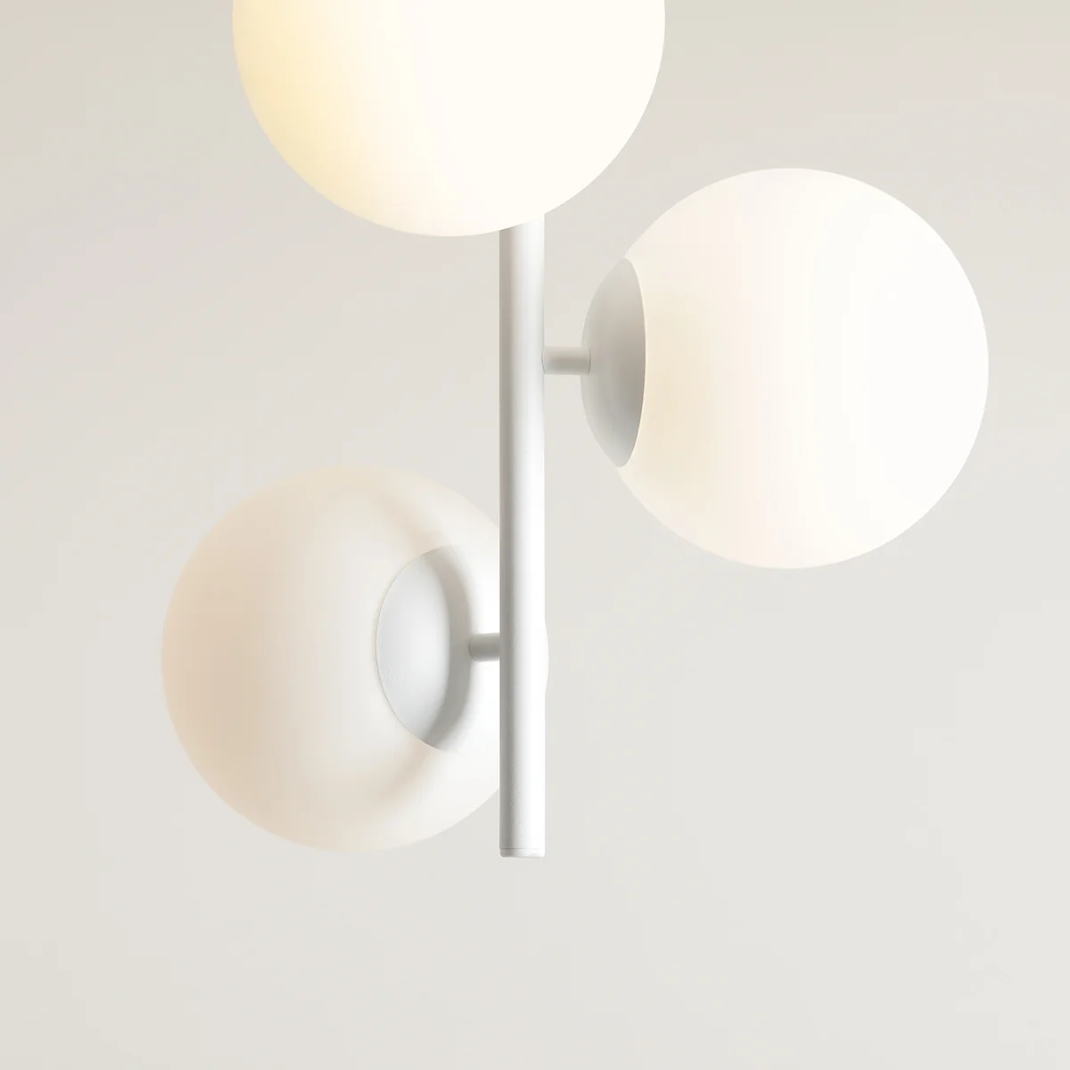 Lampa sufitowa Fin M 3-punktowa w kolorze białym. Posiada trzy okrągłe, matowe klosze umieszczone na prostym, białym stelażu. Ujęcie z góry, pokazujące detale kloszy i ich rozmieszczenie.