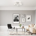 Lampa sufitowa Parma w kolorze białym, z trzema oprawami GU10 i jedną LED, zamontowana na suficie. Prosty, okrągły kształt. W tle aranżacja wnętrza z szarymi ścianami i nowoczesnymi obrazami.