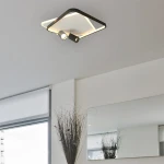 Lampa sufitowa Parma 2xGU10, czarna, w kształcie kwadratu, z dwoma ruchomymi reflektorami LED. Ujęcie z dołu, montowana na suficie, w nowoczesnym wnętrzu z lustrem i rośliną w tle.
