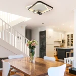 Lampa sufitowa Parma 2xGU10 w kolorze czarnym, z kwadratowym designem. Posiada dwa ruchome źródła światła oraz delikatne podświetlenie. Zainstalowana w nowoczesnej kuchni, na tle drewnianego stołu i białych krzeseł.