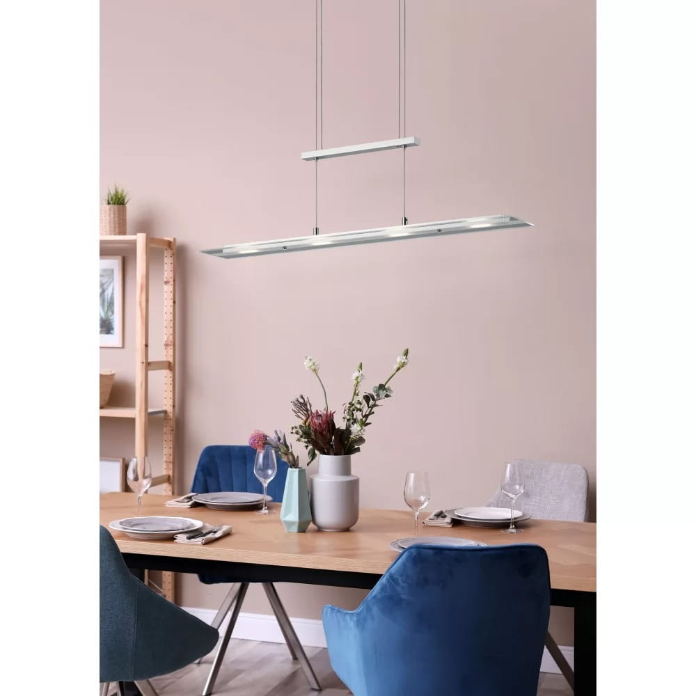 Lampa wisząca Milos 4xLED/20W w kolorze niklowym, zawieszona nad drewnianym stołem. Posiada dwa poziomy, z prostokątnymi kloszami. Otoczenie to nowoczesna jadalnia z niebieskimi krzesłami i wazonem z kwiatami. Tło w neutralnym odcieniu.