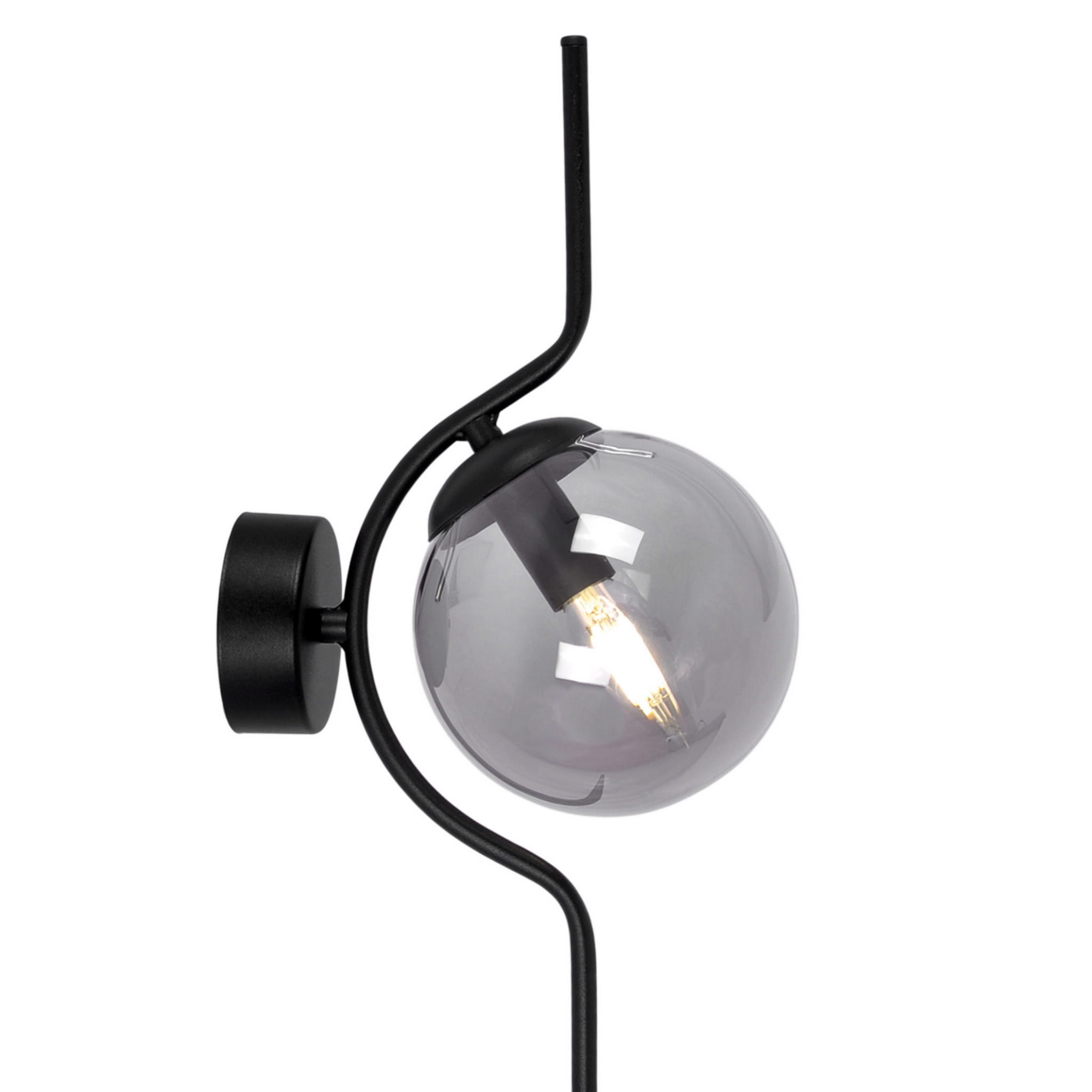 Kinkiet Neva z pojedynczym źródłem światła E14, w kolorze czarnym i grafitowym. Okrągła, przezroczysta klosz w odcieniu szarym, zamontowany na cienkiej, metalowej ramie. Ułożenie: stojący na ścianie, z delikatnie wygiętą formą.