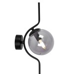 Kinkiet Neva z pojedynczym źródłem światła E14, w kolorze czarnym i grafitowym. Okrągła, przezroczysta klosz w odcieniu szarym, zamontowany na cienkiej, metalowej ramie. Ułożenie: stojący na ścianie, z delikatnie wygiętą formą.