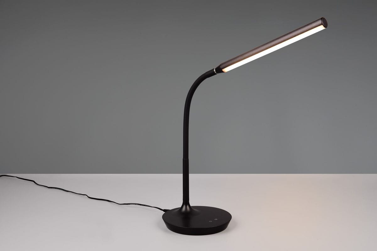 Czarna lampa stołowa Toro z elastycznym ramieniem, z pojedynczym źródłem światła LED o mocy 5W. Pozycjonowana w lekko zgiętej formie, z okrągłą podstawą i widocznym przewodem zasilającym. Prosta i nowoczesna konstrukcja idealna do biura lub wnętrza.