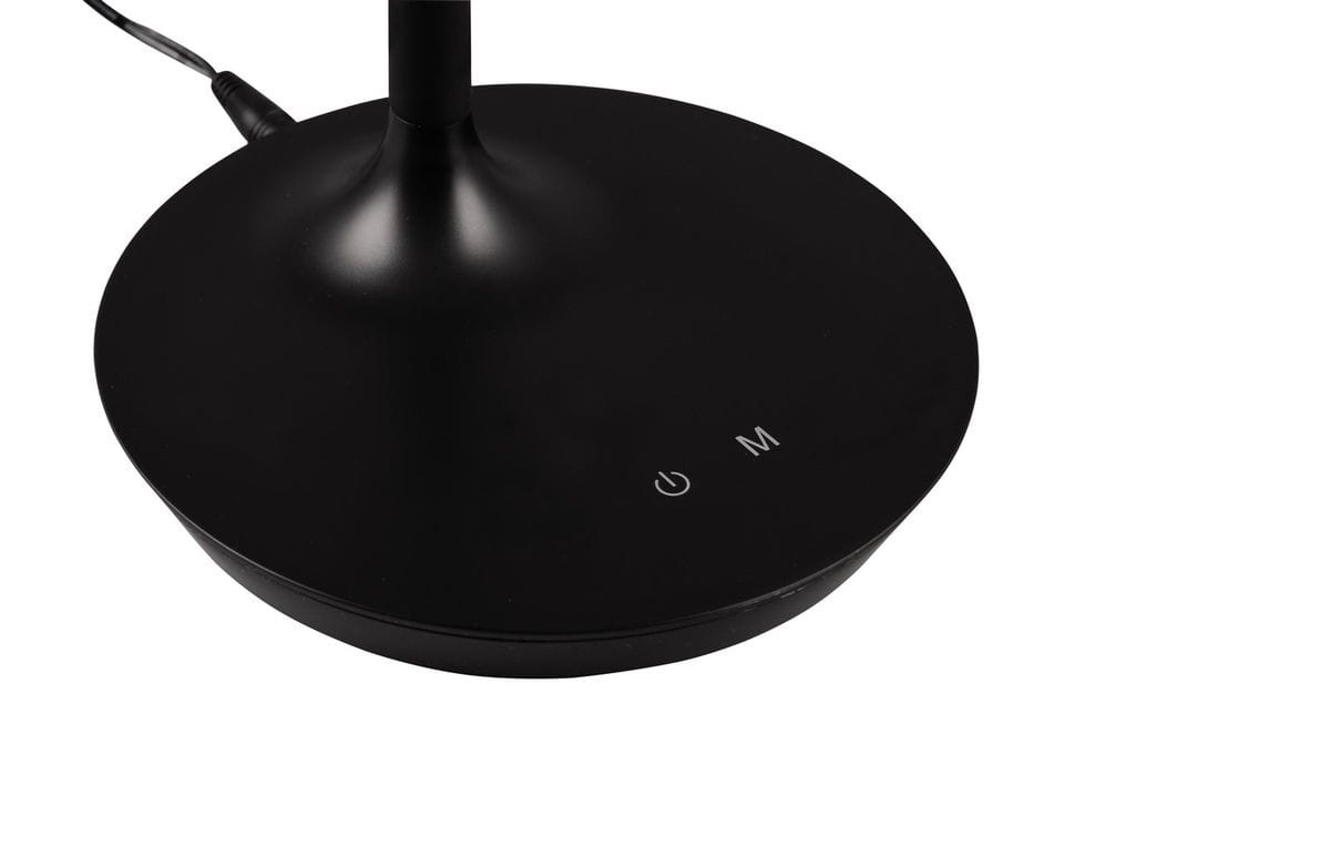 Czarna lampa stołowa Toro z podstawą o okrągłym kształcie. Widoczny przycisk z oznaczeniem ON/OFF oraz M. Ujęcie z góry, prezentujące detale podstawy i kable.