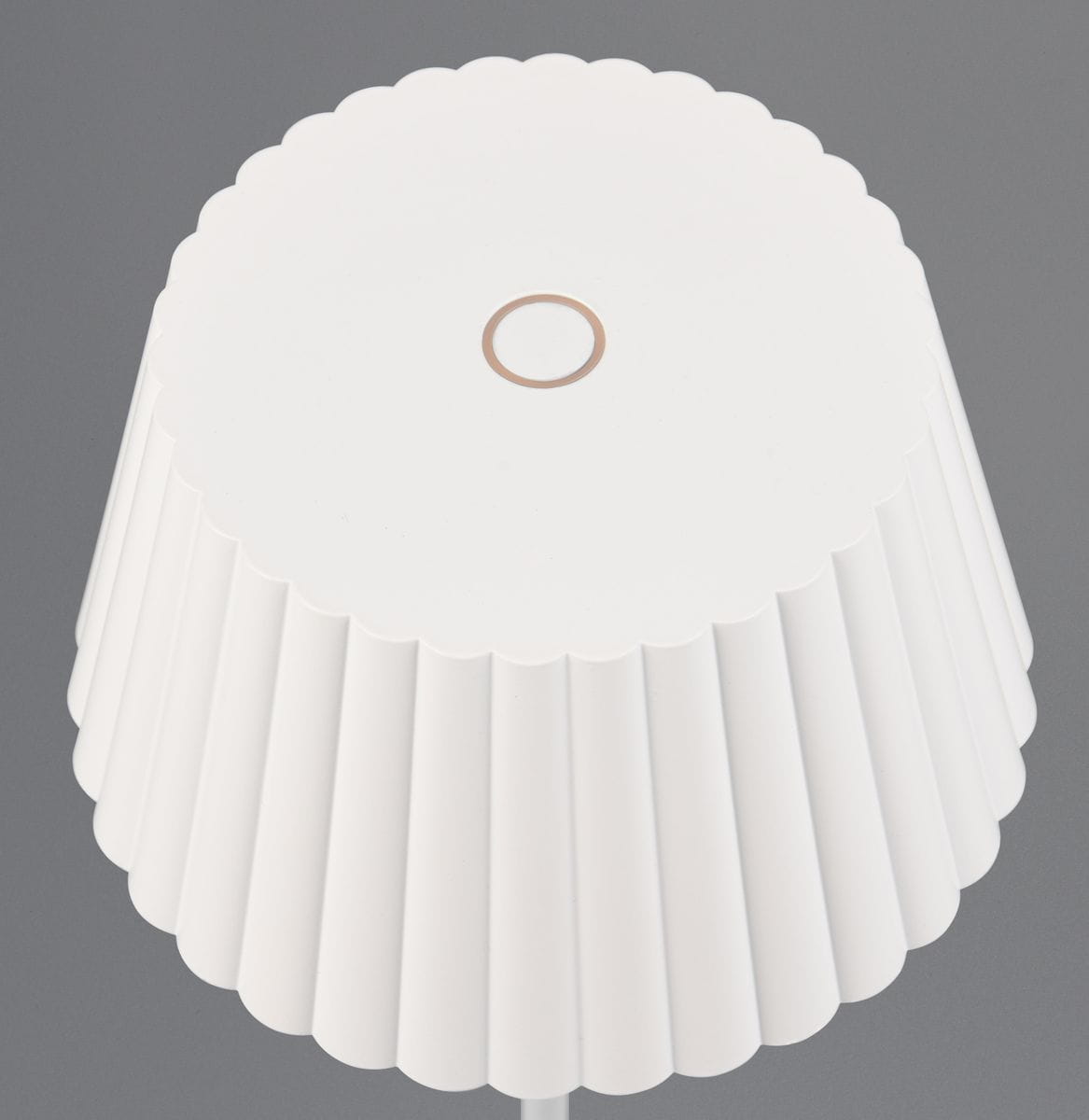 Lampa stołowa Suarez w białym kolorze, z kloszem w formie żebrowanej, z centralnym otworem. Ujęcie z góry, ukazujące fakturę oraz kształt klosza. Wbudowane źródło LED o mocy 1,5W.