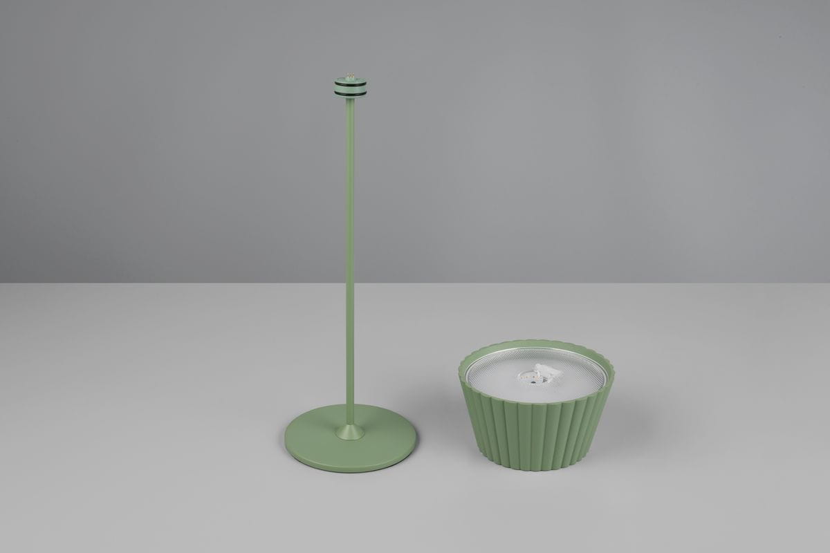 Lampa stołowa zewnętrzna Suarez w kolorze zielonym, składająca się z wysokiego stojaka i okrągłej podstawy z teksturowanym wzorem. Stojak ma prostą formę, a lampa wyposażona jest w źródło LED o mocy 1,5W. Ujęcie z boku na jasnym tle.