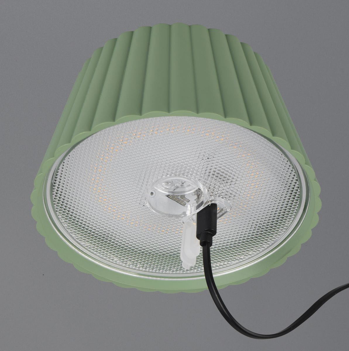 Lampa stojąca zewnętrzna Suarez w kolorze zielonym, z kloszem w falistym kształcie. Widoczny element LED o mocy 1,5W i czarny przewód zasilający. Ujęcie z góry, ukazujące detale klosza i źródło światła.