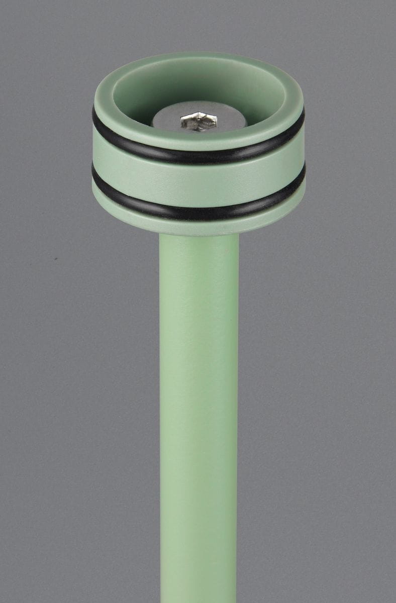 Lampa stojąca zewnętrzna Suarez w kolorze zielonym, z jedną diodą LED o mocy 1,5W. Widoczny detal u góry lampy z metalowym mocowaniem. Prosta, cylindryczna konstrukcja z matowym wykończeniem. Tło szare, co podkreśla kolor lampy.