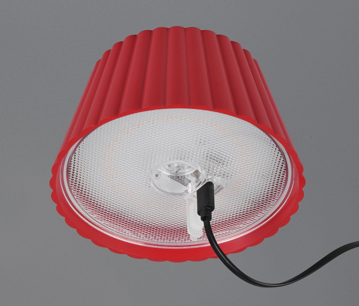 Lampa stojąca zewnętrzna Suarez w kolorze czerwonym, z okrągłym kloszem z teksturowanego plastiku. Widoczny przewód zasilający. Ujęcie z góry, ukazujące strukturę klosza oraz źródło światła LED o mocy 1,5W.