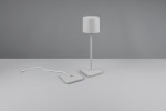 Lampa stołowa zewnętrzna Fernandez w ciemnoszarym kolorze, wykonana z metalu, z cylindrycznym kloszem. Stoi na kwadratowej podstawie. Widoczny kabel zasilający. Ujęcie frontalne, produkt w pozycji stojącej na jednolitym tle.