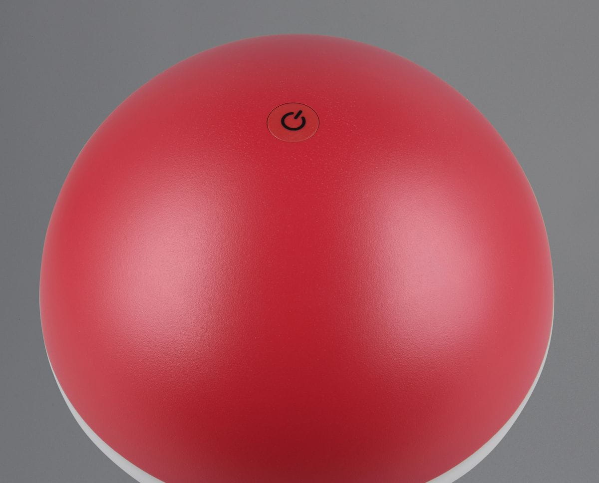 Lampa stołowa Fungo zewnętrzna w kolorze czerwonym, okrągła, z przyciskiem włączania na górze. Wykonana z matowego materiału, z białą podstawą. Źródło światła LED o mocy 2W. Ujęcie z góry, pokazujące detal i teksturę powierzchni.