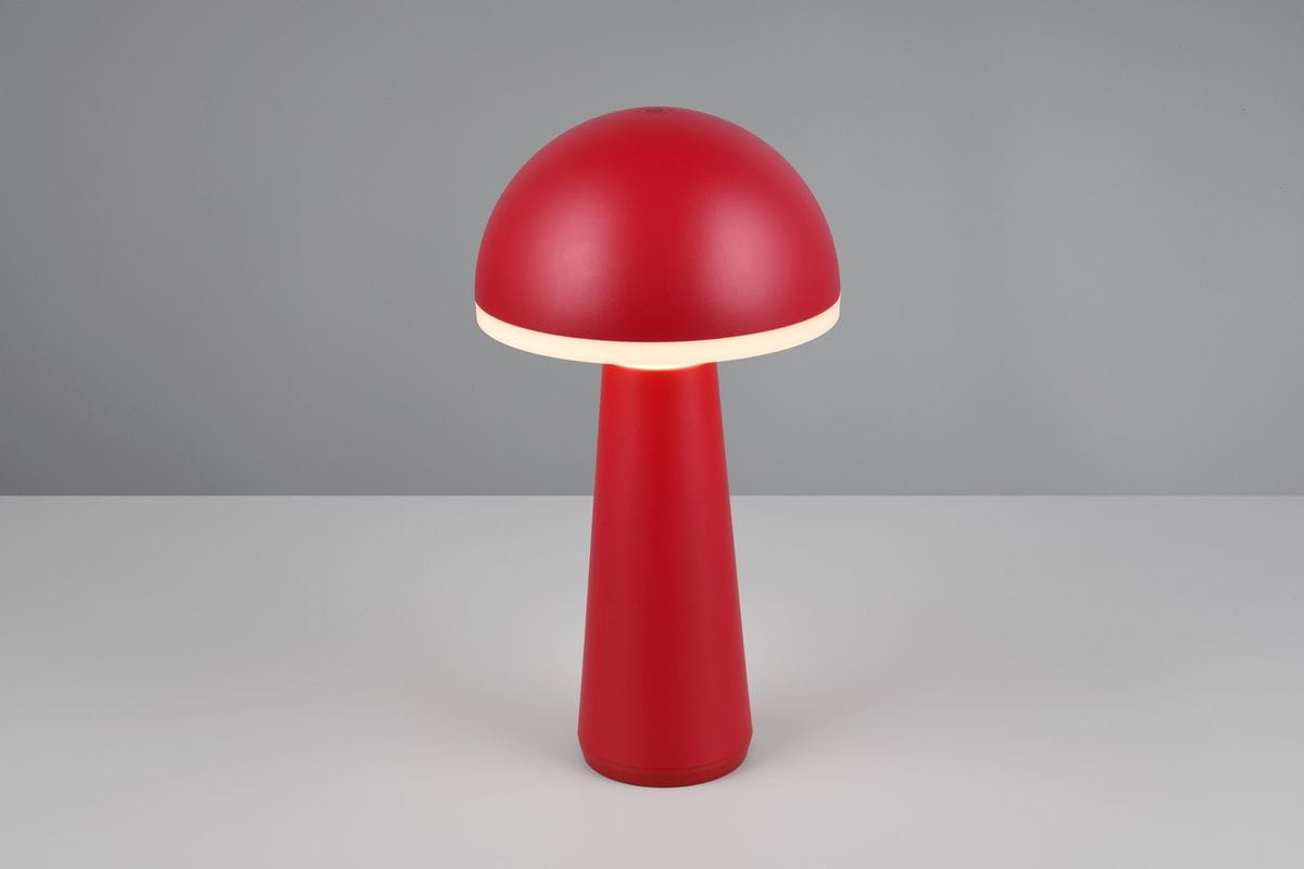 Czerwona lampa stołowa Fungo z zewnętrznym źródłem światła LED (2W) o kształcie grzyba. Posiada matową, okrągłą czaszę i stożkowaty korpus. Ustawiona na płaskiej powierzchni, o prostej, szarej tle.