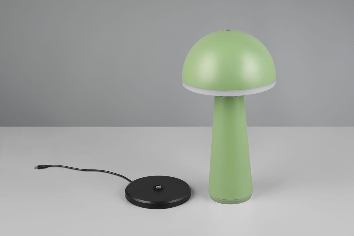 Zielona lampa stołowa Fungo zewnętrzna, z kształtem grzyba, z mlecznym kloszem i podstawą w kolorze czarnym. Widoczny kabel zasilający. Lampa LED (1x2W) idealna do użytku na zewnątrz. Stoi na płaskiej powierzchni.