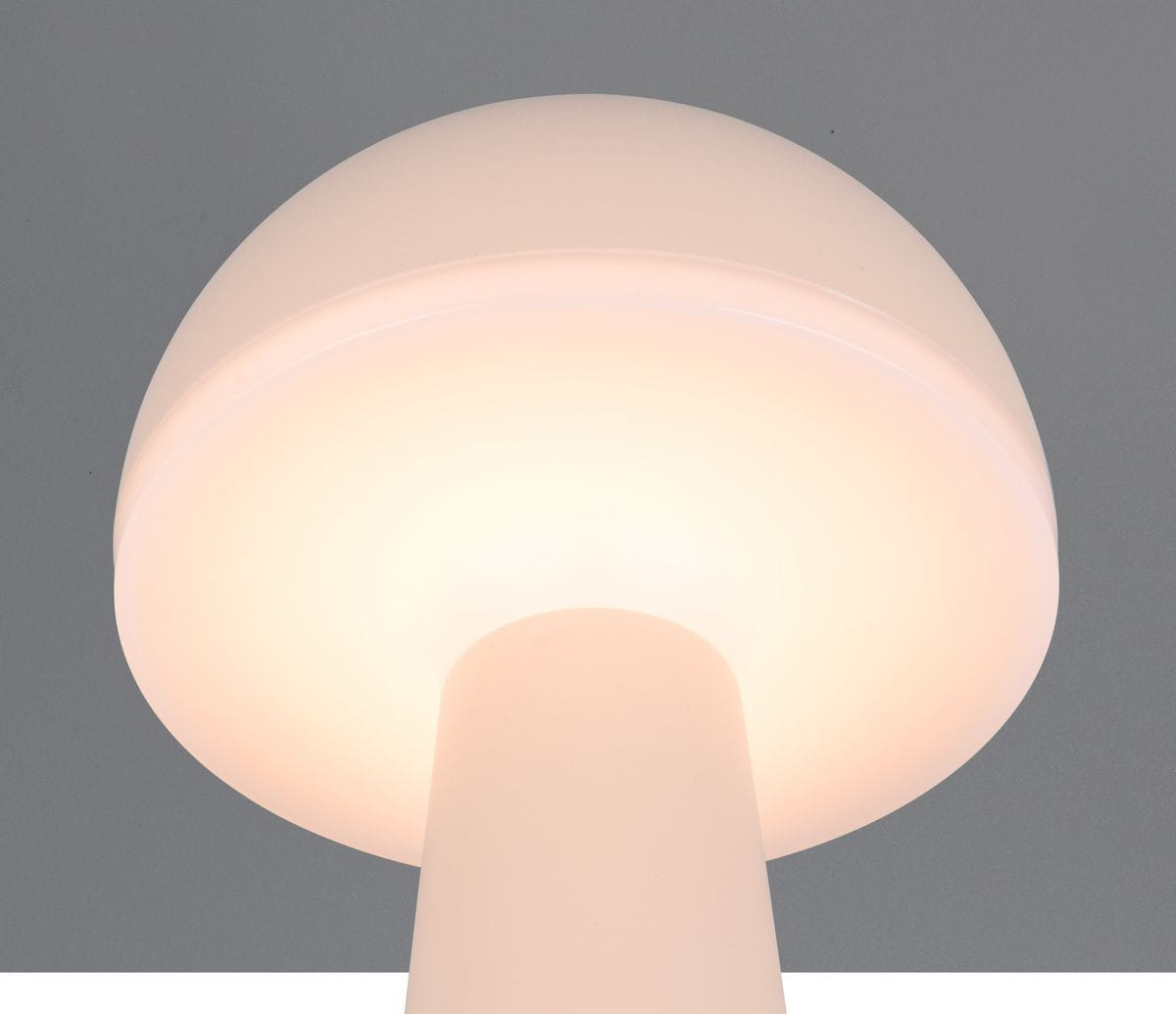 Lampa stołowa zewnętrzna Fungo, piaskowa, z okrągłym kloszem i prostym słupkiem. Źródło światła LED 1x2W. Ujęcie z dołu, ukazujące gładką, matową powierzchnię klosza oraz emitowane ciepłe światło. Tło w odcieniu szarości.