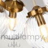 Lampa wisząca Cosmos z dziewięcioma oprawami E14, w antycznej bieli i mosiądzu. Szklane klosze o falistej fakturze, montowane na metalowych mocowaniach w kolorze mosiądzu, wiszące z sufitu.