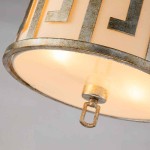 Lampa wisząca Lemuria w kolorze starego złota, z okrągłym abażurem osłoniętym jasnym materiałem. Widoczny detal mocowania oraz metalowe wykończenie. Produkt przeznaczony na dwie żarówki E27. Umiejscowiona w górnej części zdjęcia.
