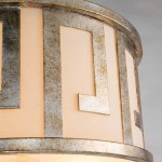 Lampa wisząca Lemuria w starym złocie, z detalami geometrycznymi. Okrągły klosz z jasnymi wstawkami, w zbliżeniu na teksturę i efekt metaliczny. Zawiera dwa gniazda E27, idealna do nowoczesnych wnętrz.