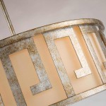 Lemuria lampa wisząca w kolorze starego złota, z okrągłym kloszem z metalową ramą w geometrycznym wzorze oraz jasnym, materiałowym wnętrzem. Ujęcie z góry, ukazujące detale konstrukcji i fakturę metalu.