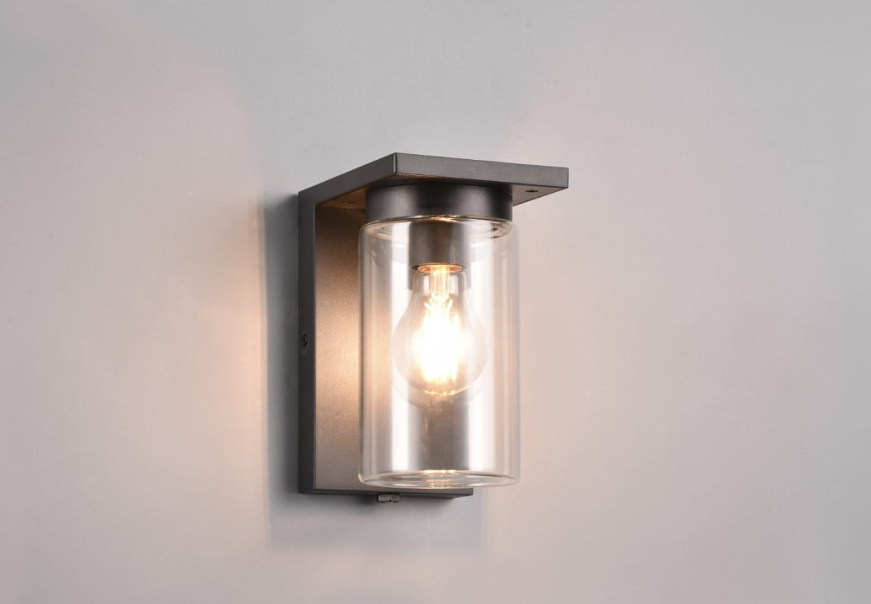 Kinkiet zewnętrzny Ardila w kolorze czarnym, 1-punktowy, z przezroczystym kloszem, w którym widoczna jest żarówka. Montowany na ścianie, z czujnikiem zmierzchu, prostokątny kształt, metalowa konstrukcja. Oświetlenie idealne do przestrzeni zewnętrznych.