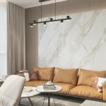 Lampa wisząca Noe w kolorze czarnym z sześcioma punktami świetlnymi GU10. Zawieszona na prostokątnej konstrukcji, umieszczona nad sofą w nowoczesnym wnętrzu z marmurową ścianą i stylowym wystrojem.