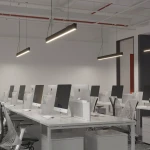 Lampa wisząca Sigi III w kolorze czarnym, z jedną diodą LED o mocy 36W i temperaturze barwowej 3000K. Umieszczona w nowoczesnym biurze, zawieszona na cienkich linkach, o prostokątnym kształcie, zapewniająca równomierne oświetlenie przestrzeni roboczej.