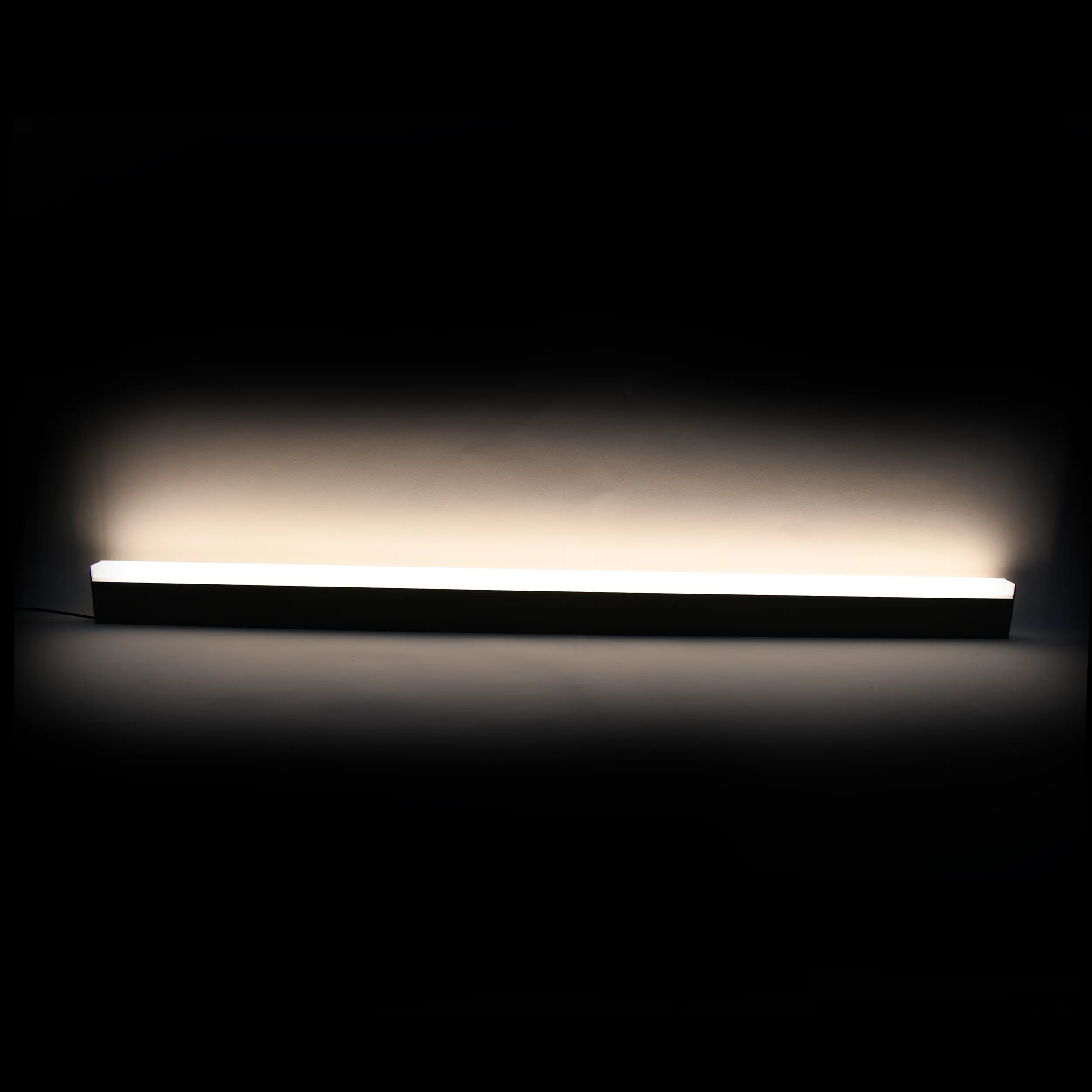 Lampa wisząca Sigi IV, czarna, z jedną diodą LED o mocy 36W i temperaturze barwowej 3000K. Prosta, prostokątna konstrukcja z matowego materiału, zawieszona w poziomie, emitująca ciepłe światło. Tło ciemne, podkreślające wygląd lampy.