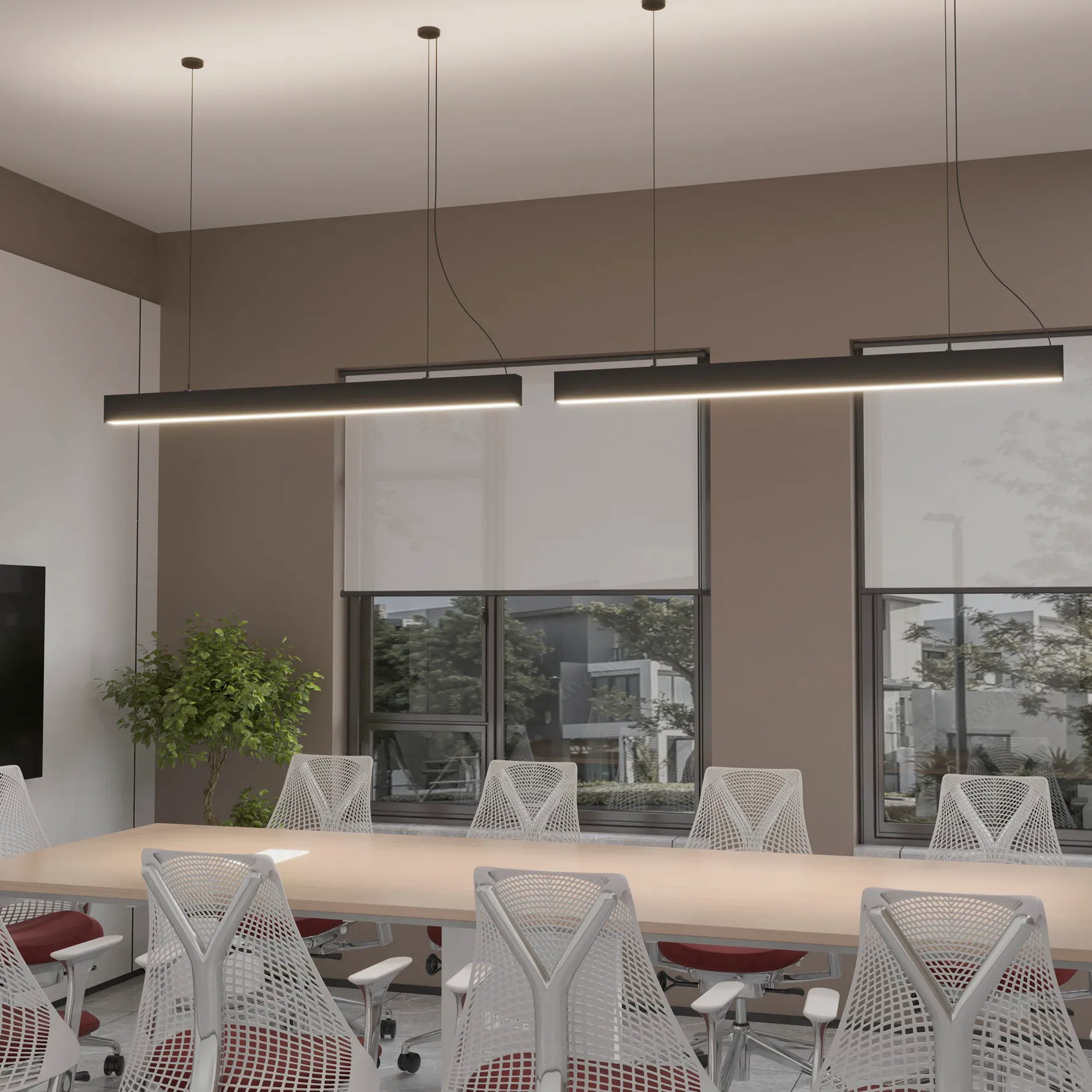 Lampa wisząca Sigi V w kolorze czarnym, z dwiema liniowymi oprawami LED. Zawieszona na cienkich linkach w nowoczesnym biurze, nad dużym stołem konferencyjnym, w tle okna z roletami. Emituje ciepłe światło 3000K.