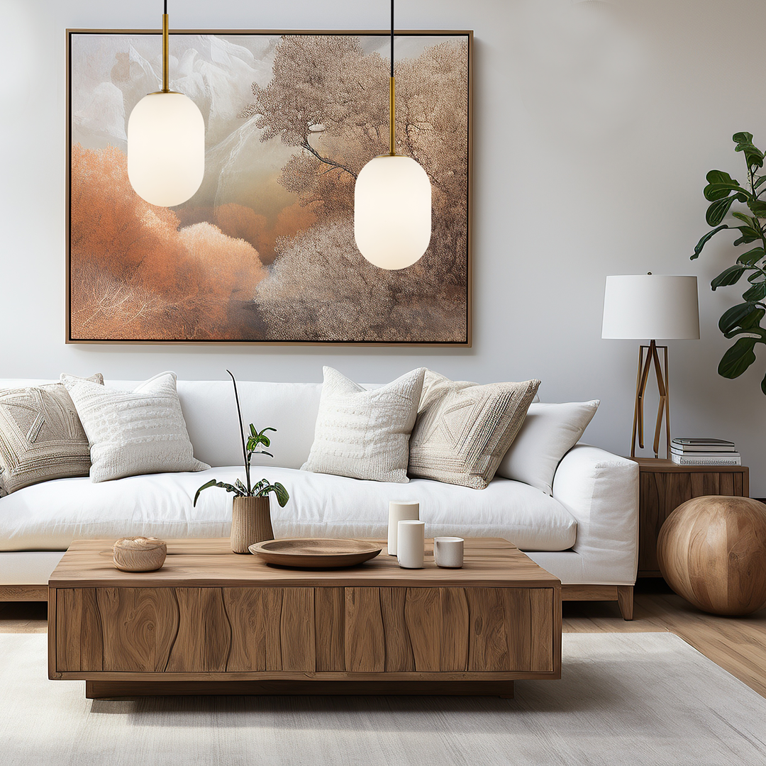 Lampa wisząca Alias D12 z opalowym kloszem i złotymi detalami, zawieszona w przestronnym wnętrzu. Widoczna w aranżacji obok sofy z poduszkami, drewnianego stolika oraz obrazu z naturalnym motywem.