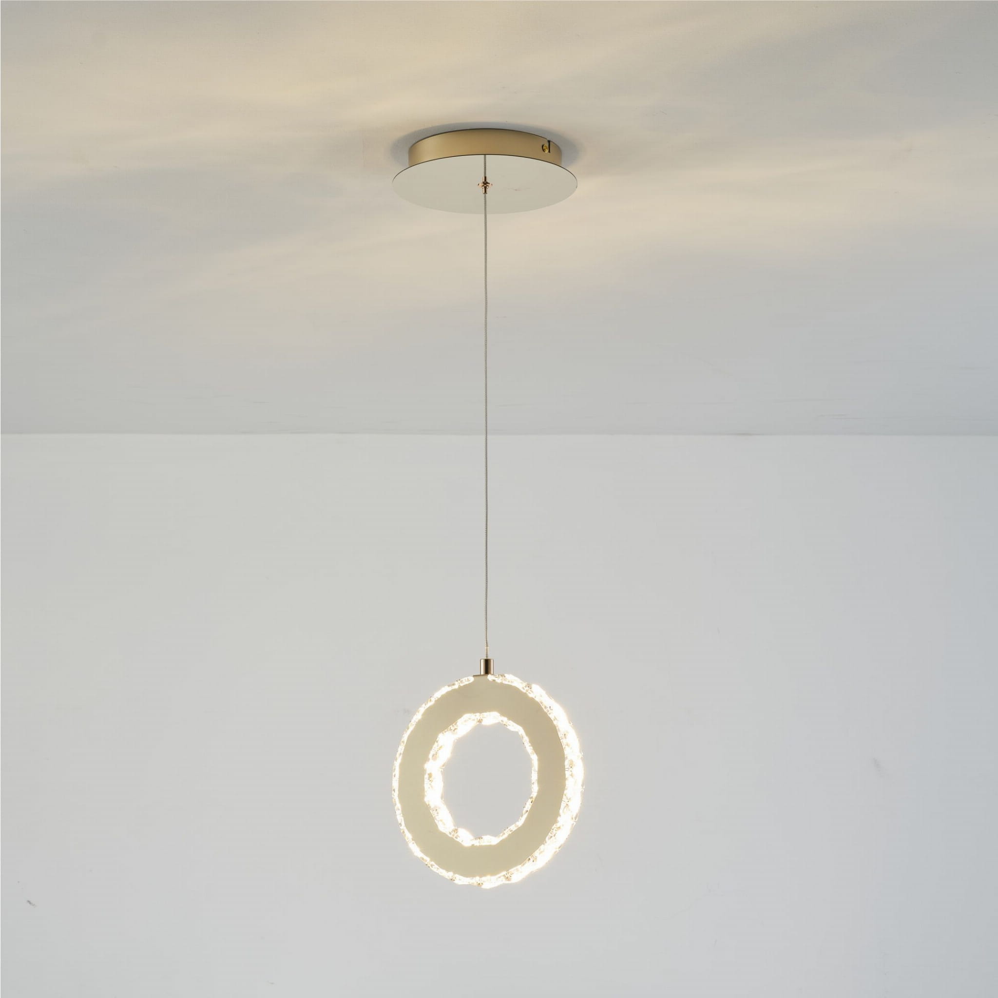 Girona lampa wisząca 1xLED/10W w kolorze złotym, w kształcie pierścienia z przezroczystymi detalami, zawieszona na cienkim przewodzie. Ujęcie frontalne, na białym tle, ukazujące nowoczesny design i eleganckie wykończenie.