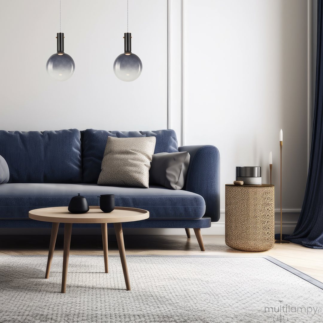 Czarna lampa wisząca Toronto z jednym miejscem na żarówkę GU10, zawieszona w eleganckim wnętrzu. Lampa ma szklany klosz, stylowo oświetlając niebieską sofę i drewniany stolik z czarnymi akcesoriami.