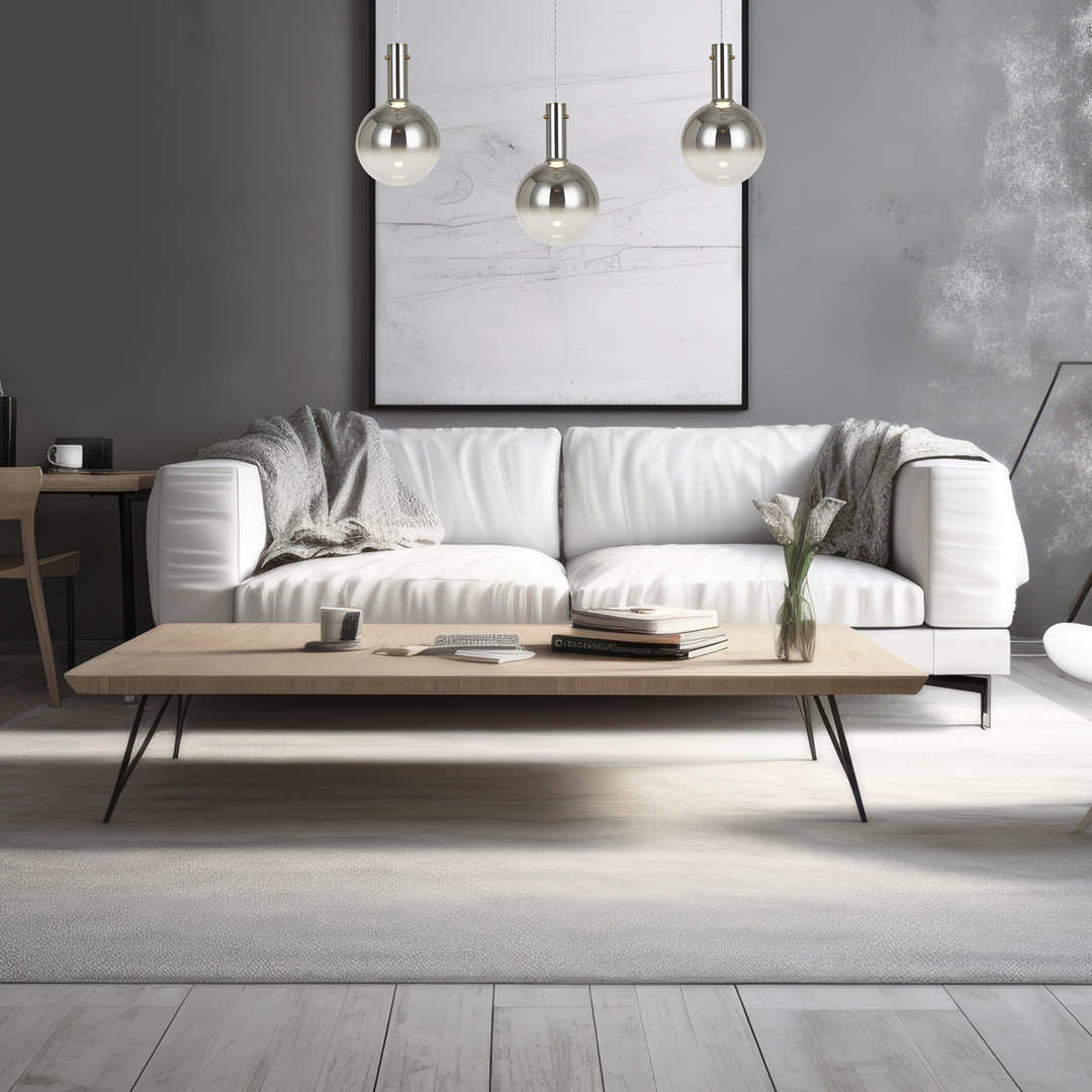 Lampa wisząca Toronto z chromowanym wykończeniem i kulistymi kloszami, zawieszona na cienkich linkach. W tle nowoczesny salon z białą sofą, drewnianym stolikiem i minimalistyczną dekoracją.