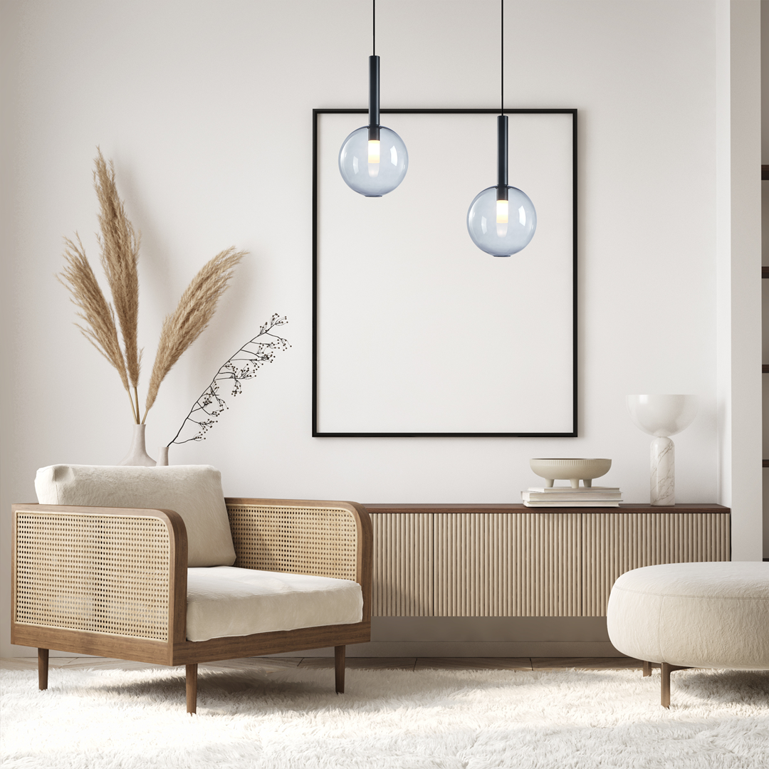 Czarna lampa wisząca Niko D20 z pojedynczym źródłem światła G9, umieszczona w nowoczesnym wnętrzu. Lampa zawieszona nad stolikiem, obok stylowego fotela z naturalnym wykończeniem i dekoracjami roślinnymi.