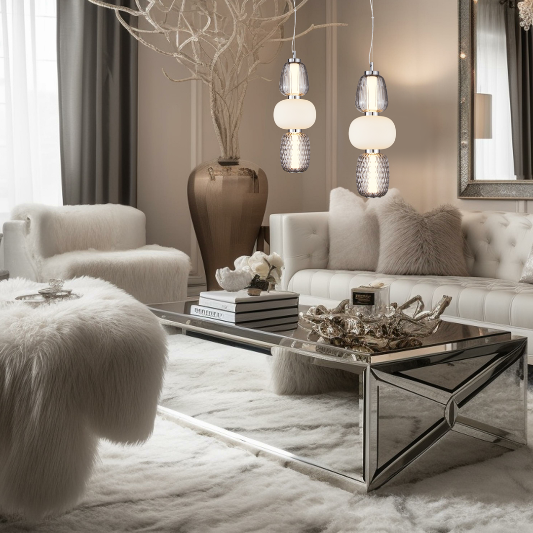 Lampa wisząca Caro z chromowanym wykończeniem, posiadająca trzy klosze: przezroczysty, biały i wzorzysty. Zawieszona w eleganckim wnętrzu, obok białych mebli oraz dekoracyjnych elementów. Idealna do nowoczesnych aranżacji.