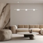Lampa wisząca Genesis 7xGU10 w białym kolorze, zamontowana na suficie. Posiada prostą, minimalistyczną konstrukcję z sześcioma okrągłymi kloszami rozmieszczonymi na długim ramieniu. W tle widoczny jasny salon z kanapą i okrągłym stołem.