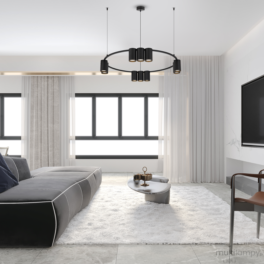 Czarna lampa wisząca Genesis z 10 gniazdami GU10, zawieszona na dwóch cienkich linkach. Lampa ma okrągły kształt i minimalistyczny design, umieszczona w nowoczesnym wnętrzu z jasnymi oknami i szarym narożnikiem.
