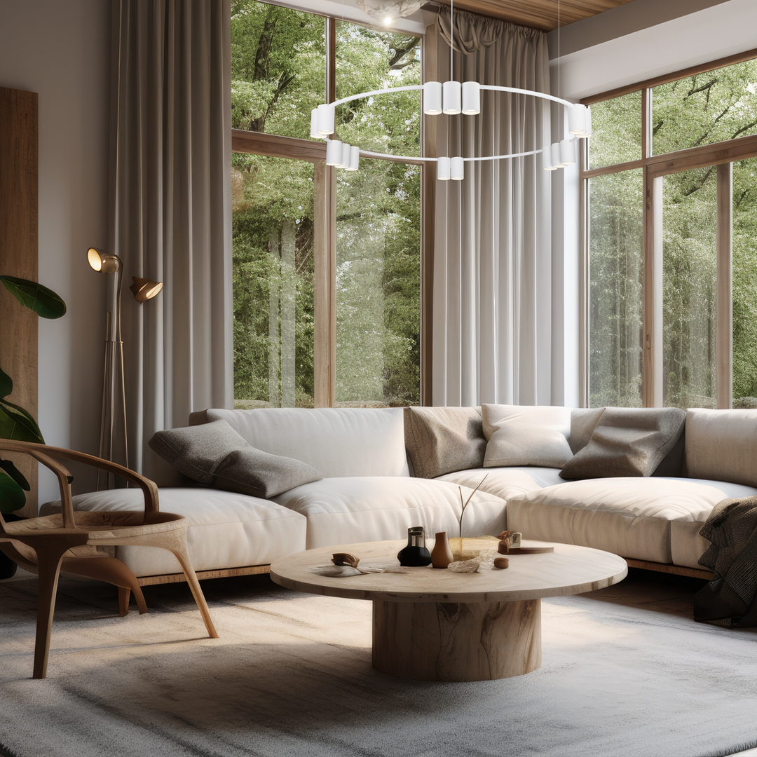 Lampa wisząca Genesis w kolorze białym z 15 miejscami na żarówki GU10. Zamontowana w nowoczesnym wnętrzu, zawieszona nad okrągłym, drewnianym stołem. Otoczenie z jasną sofą i dużymi oknami, co tworzy przytulną atmosferę.