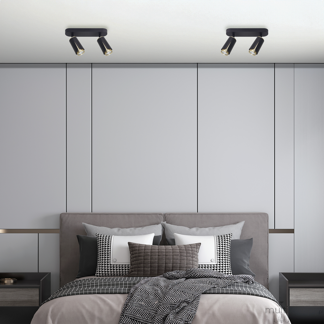 Lampa sufitowa Flower w kolorze czarnym i złotym z dwoma reflektorami GU10, zamontowana na suficie. Widok z góry, w nowoczesnym wnętrzu sypialni z szarymi ścianami i łóżkiem z poduszkami.