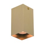Lampa sufitowa Ander w kolorze mosiężnym, w kształcie prostopadłościanu. Posiada jedno miejsce na żarówkę GU10, widoczny delikatny wzór na powierzchni. Kąt ujęcia z boku, ukazujący dolną część lampy oraz emitowane światło.