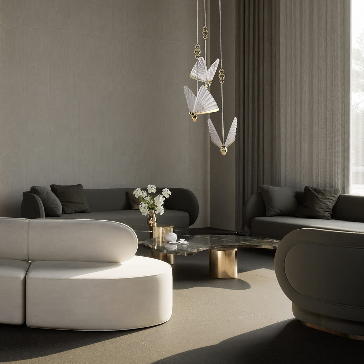 Lampa wisząca Mariposa z trzema źródłami LED o mocy 24W, w złotym kolorze, z dekoracyjnymi, białymi skrzydłami. Zawieszona w nowoczesnym wnętrzu, w otoczeniu kanap i stolika kawowego.