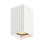 Lampa sufitowa Tecno 1xGU10 w kolorze białym, z prostokątną, żłobioną obudową. Ujęcie z boku, ukazujące żarówkę wewnątrz. Produkt montowany na suficie, z widocznym detalem struktury materiału.
