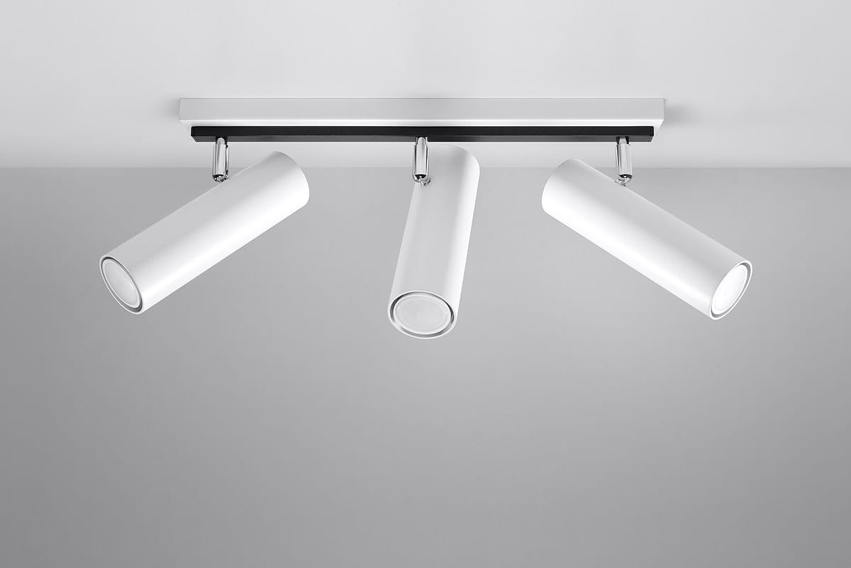 Lampa sufitowa Direzione 3-punktowa w kolorze białym. Składa się z trzech cylindrycznych reflektorów umieszczonych na prostokątnej, metalowej podstawie. Reflektory są skierowane w różnych kierunkach, co umożliwia regulację oświetlenia.