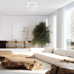 Biała lampa sufitowa Volf z dwoma spotami GU10, zamontowana na suficie. Lampa o minimalistycznym designie, umieszczona w jasnym, nowoczesnym wnętrzu z dużymi oknami, jasną sofą i drewnianym stolikiem.