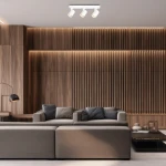 Lampa sufitowa Volf z trzema reflektorami GU10 w białym kolorze, zamontowana na jasnym suficie. Reflektory są skierowane w różne strony, a produkt jest umieszczony w nowoczesnym wnętrzu z drewnianą ścianą i sofą.