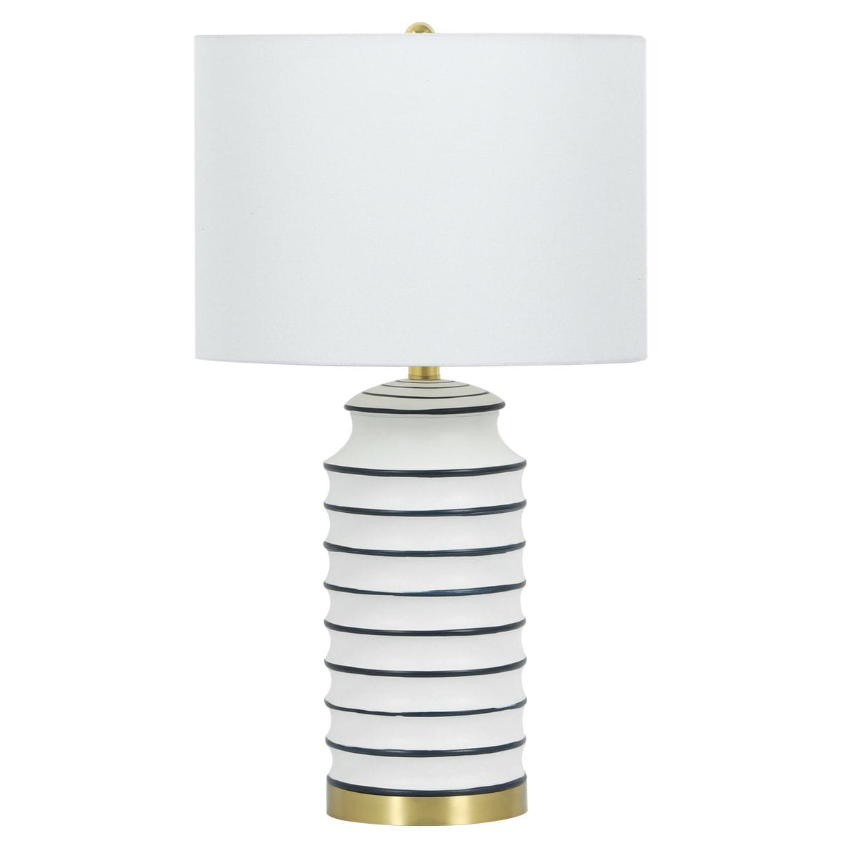 Lampa stołowa Coastal z białym abażurem i podstawą z mosiądzu, w kształcie cylindrycznym z poziomymi, ciemnoniebieskimi paskami. Stoi na płaskiej powierzchni, z widocznym detalem w postaci złotego wykończenia u podstawy.